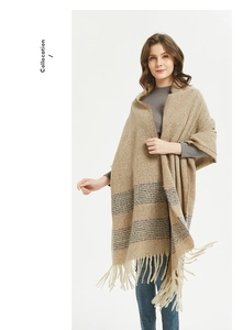 Detail view of beige knit scarf with striped patterns and fringe tassels decoration