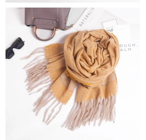 Detail of yellow plaid scarf with fringe tassels, paired with fashion accessories and magazines