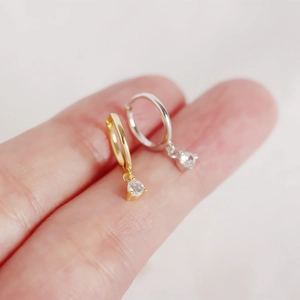 Close-up of gold and silver S925 sterling silver hoop earrings with zircon pendants
