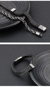 Macro view of a dark grey mesh woven stainless steel bracelet with a vintage clasp