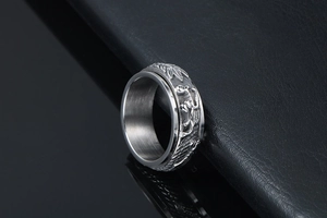 Macro shot of silver spinning ring featuring detailed dragon relief and punk style carvings