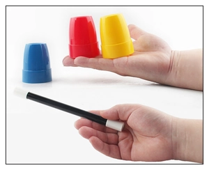 Detailed view of colorful magic cups and wand being held for children's trick sets
