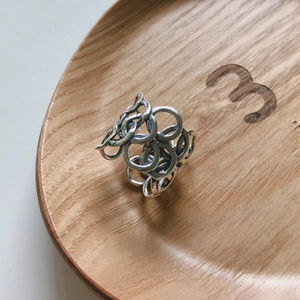 Macro shot of vintage 925 sterling silver chain ring with textured finish on wood tray