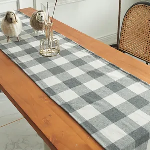 Classic black and white checkered table runner on a wooden dining table in Nordic style