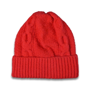 Red cable knit beanie with wide rolled cuff for winter warmth on white background