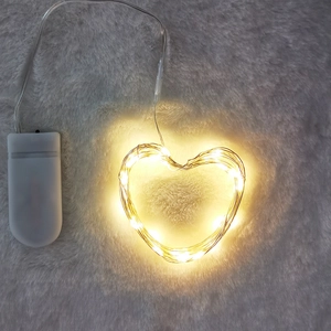 Warm white heart shaped LED string lights with copper wire and battery box on soft fur