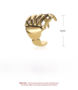 Detailed view of skull hand ear cuff in vintage gold copper finish with 1cm size