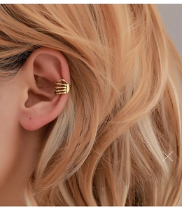 Gros plan détaillé sur un clip d'oreille doré style gothique pour femme