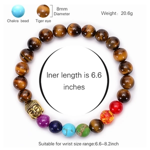 Chakra bracelet with natural tiger eye beads and golden Buddha head charm on white background