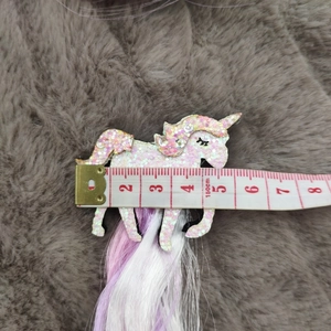Unicorn hair clip detail showing sequins and 5.5cm size measured on a tape