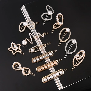 Close-up of luxury hair clips featuring faux pearls and crystals on a gold metal base