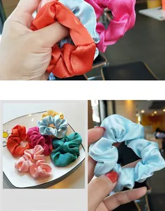 Macro detail of multi-colored satin hair scrunchies with elegant silk texture and elastic core