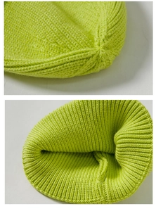 Detailed knit texture and stitching craftsmanship of the bright green knitted beanie hat