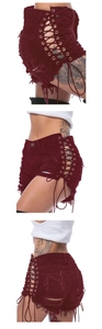 Detail of burgundy distressed denim shorts with lace-up side eyelets and frayed edges