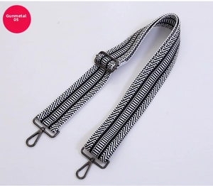 Dettaglio tracolla intrecciata geometrica bianca e nera con ganci e fibbia gunmetal