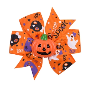 Detail of orange Halloween bow hair clip featuring 3D pumpkin and spooky patterns