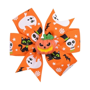 Detail of orange Halloween hair bow with pumpkin center and ghost themed print