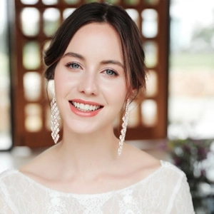 Dettaglio di orecchini a nappa in strass argentati su sposa con pizzo elegante