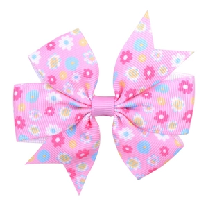 Detail of pink floral bow hair clip with ribbed texture on a clean white background