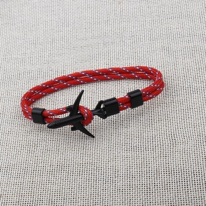 Close-up of woven paracord bracelet in red and blue with a black metal airplane clasp