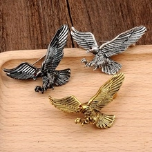 Detailed view of three vintage eagle brooches in silver, bronze, and gold finishes