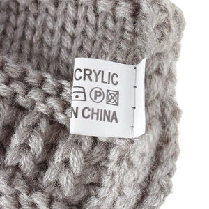 Detail der Acryl-Strickstruktur und des Pflegeetiketts für die graue Damen-Strickmütze
