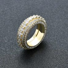 Macro di anello hip hop dorato con file multiple di zirconi trasparenti incastonati