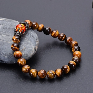 Detailed view of tiger eye crown bracelet with natural stone beads on a stone display