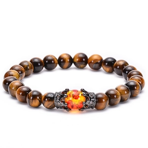 Macro detail of brown tiger eye stone bracelet with micro-pave crown and red bead