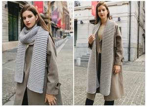 Detailed texture of gray chunky knit handmade winter scarf worn on city street