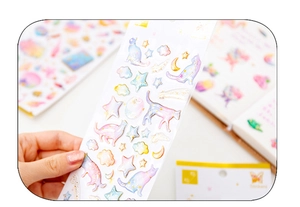 Macro detail of bronzing starry cat stickers for DIY journals with golden glitter finish