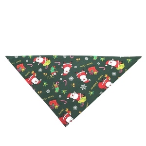 Detailed flat lay of a green Christmas dog bandana with Santa and snowflake patterns
