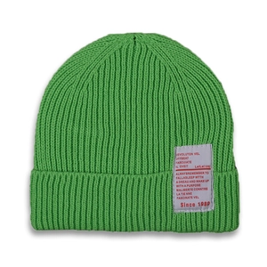 Close-up of bright green knitted beanie showing ribbed texture and vintage logo patch