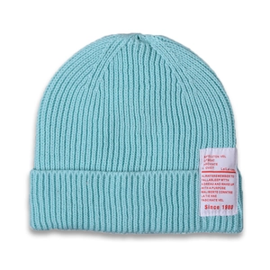 Detail of light blue ribbed knit beanie with fabric label for winter warmth