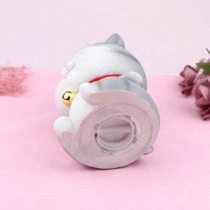 Detail view of the gray cat piggy bank base showing the white plastic coin removal plug