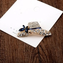 Detail of a sparkling hat brooch with white rhinestones and a blue crystal flower