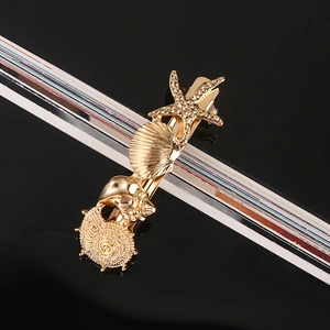 Detail of golden starfish and seashell hair clip with rhinestone and pearl accents