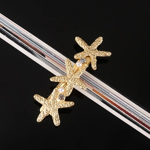 Detailed view of the gold starfish hair clip with white pearls and sparkling rhinestones