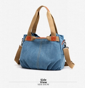 Side view of blue canvas tote bag with khaki handles and orange leather reinforcement