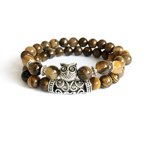 Close-up of tiger eye bead bracelet with silver owl charm and vintage metal accents