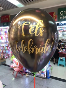 Detail of Let's celebrate! gold calligraphy sticker on black balloon for party decor