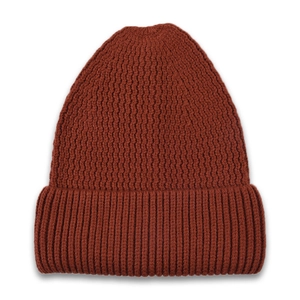 Detail of dark rust red knit beanie showing thick ribbed cuff and waffle texture pattern