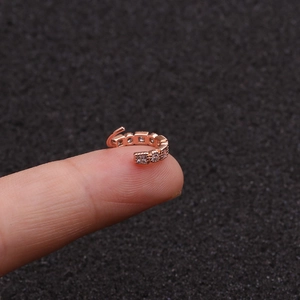 Macro shot of rose gold ear cuff with pavé cubic zirconia worn on finger for detail