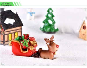 Miniature Christmas scene featuring a reindeer pulling a red sleigh filled with festive gifts