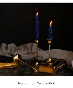 Close-up of Nordic iron candlestick with polished gold finish and elegant blue candles