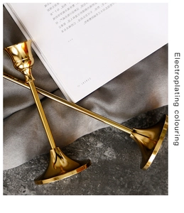 Detail of two electroplated brass candle holders with polished metallic finish