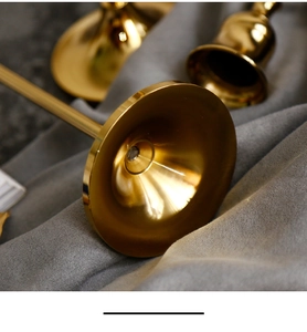 Macro shot of polished golden metal candle holder base with detailed concentric textures