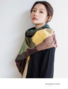 Detail of soft plaid scarf featuring deep green and yellow thick cashmere blend fabric