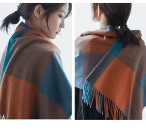 Detail view of large checkered thick shawl with tassels in brown, blue and grey patterns