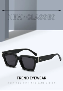 Close-up of black square sunglasses frame with golden hinge accents and premium finish
